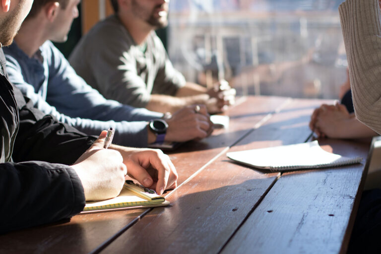 close-up of people sitting at a table having a discussion