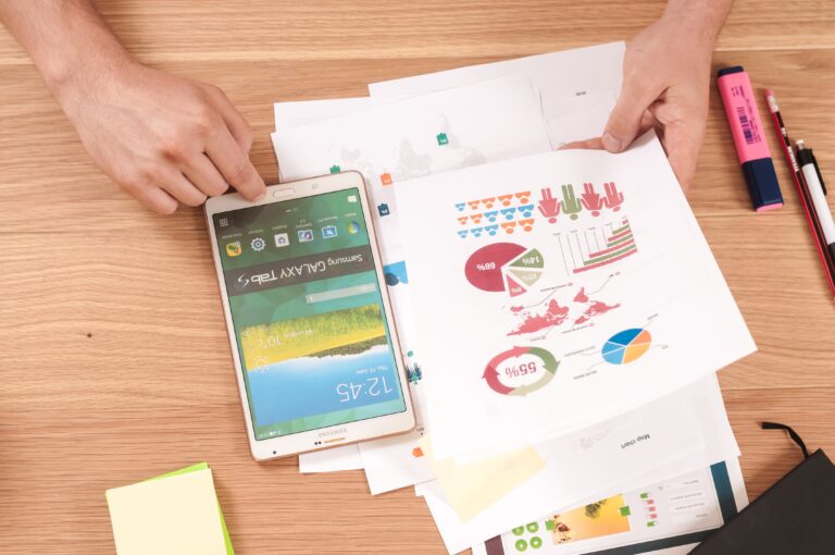 a phone an paper on a desk showing graphs