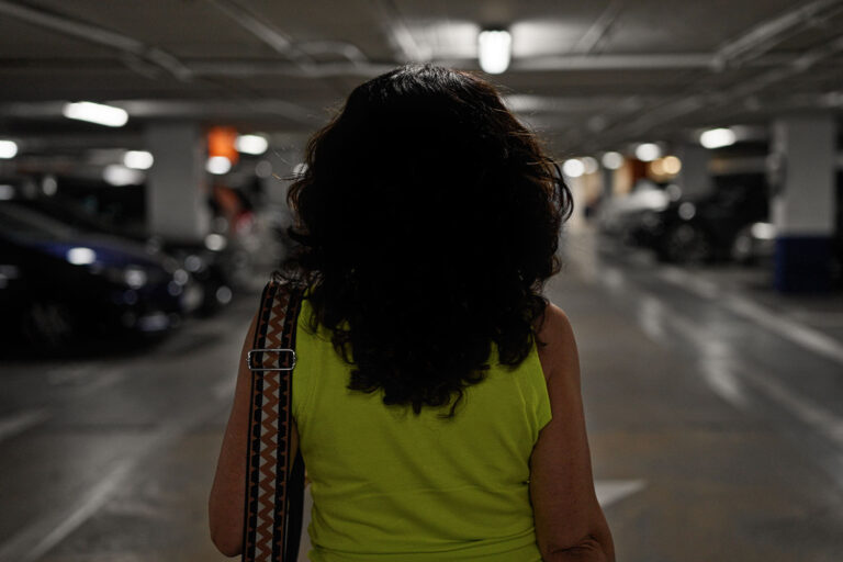 a woman walking in an indoor parking lot