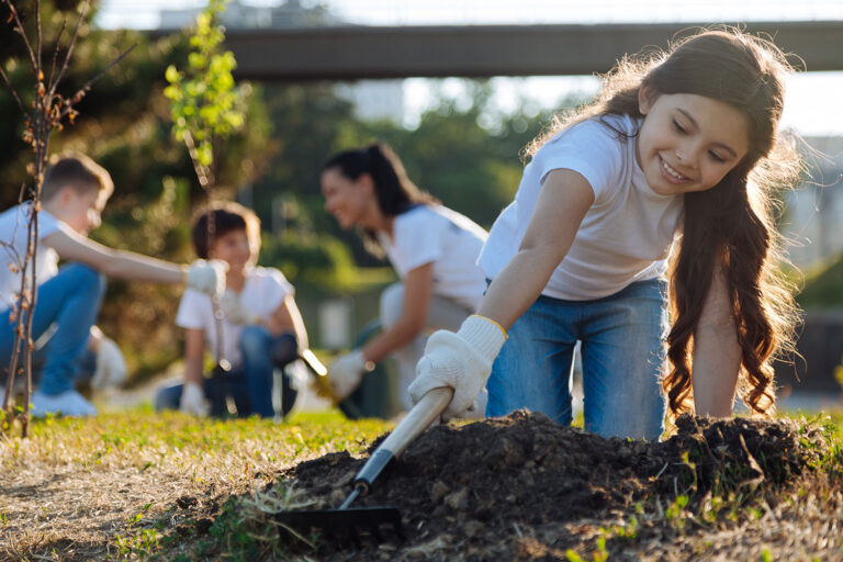 a child and others planting trees