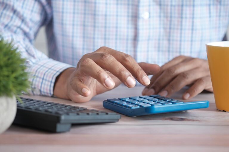 Man using calculator on a desk