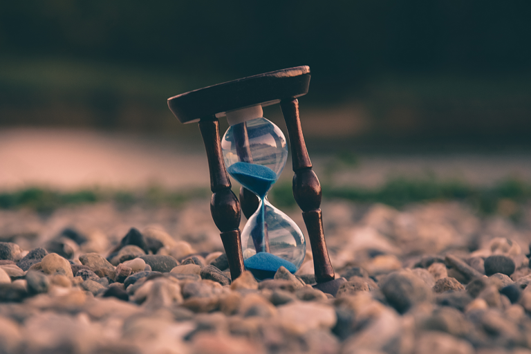 hourglass on rocky ground