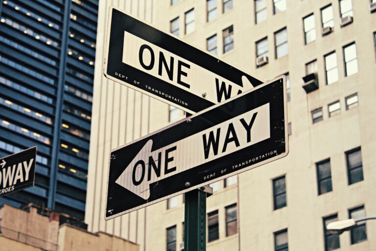 two one-way signs pointing in different directions