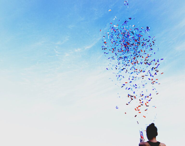 a woman shooting confetti into the air