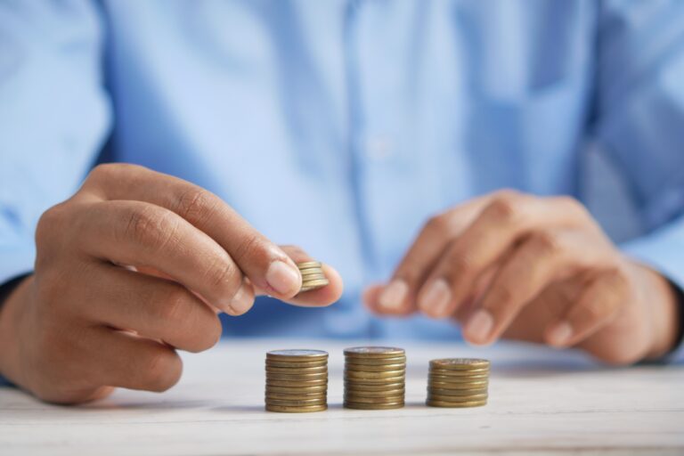 a man sitting at a desk stacking coins