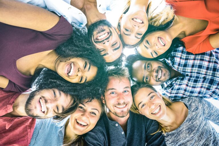 Circle of friends in a huddle, smiling