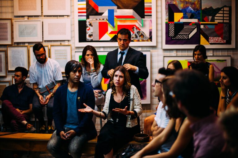 a group of people talking in front of artwork