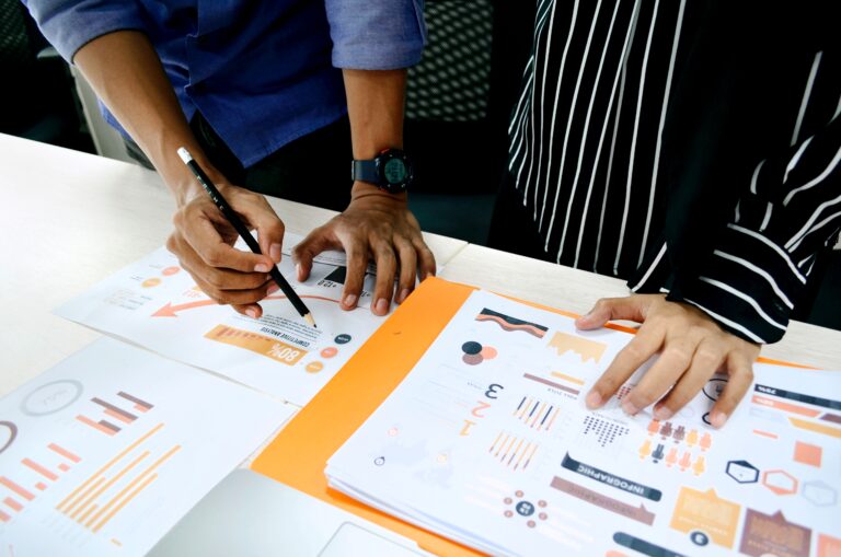 two people looking at papers with charts and graphs