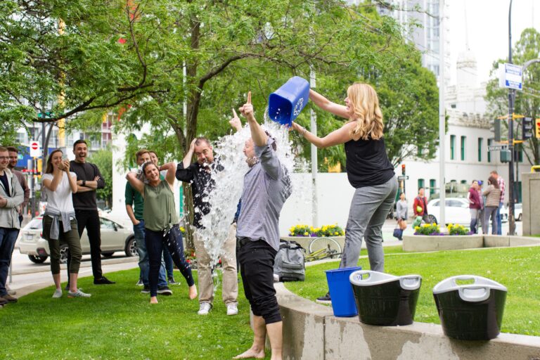 a man getting a bucket of water dumped on his head