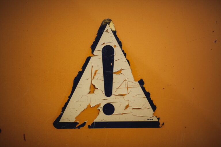 a weathered caution symbol on orange background