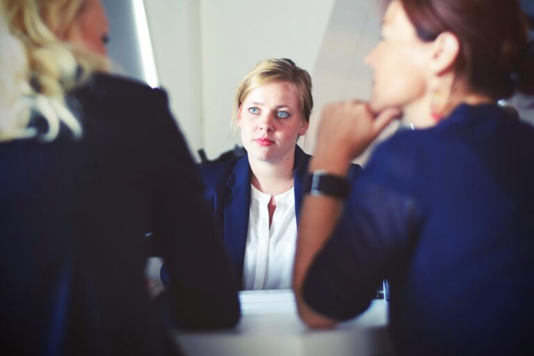 3 women sitting at a desk talking