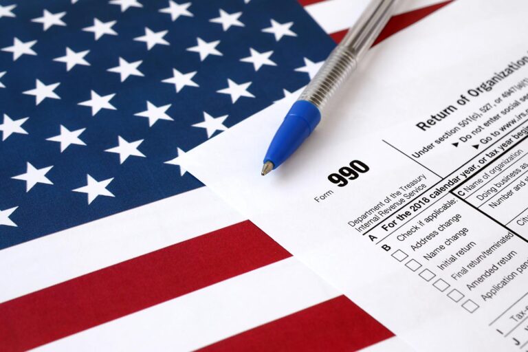 Form 990 and a pen on top of the American flag