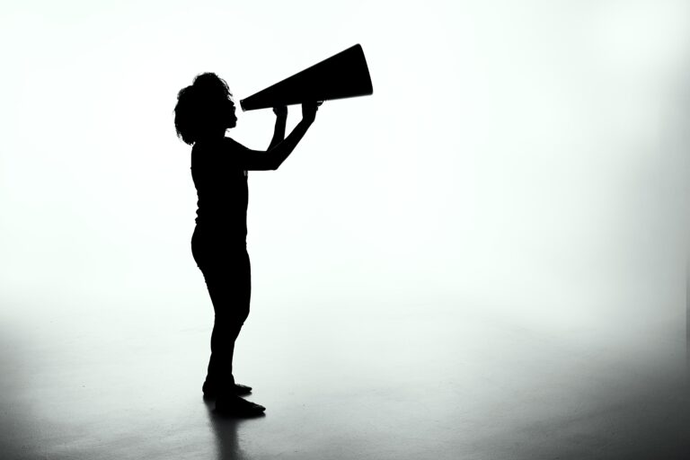 shadow of a person speaking into a megaphone