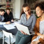 two women share a laptop