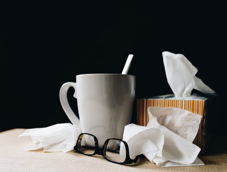 a mug, eyeglasses, and a box of tissues