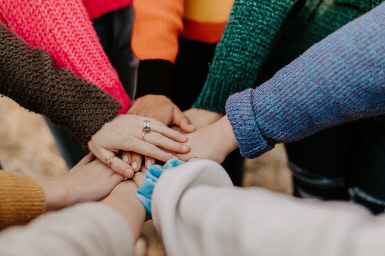 group of people putting hands together