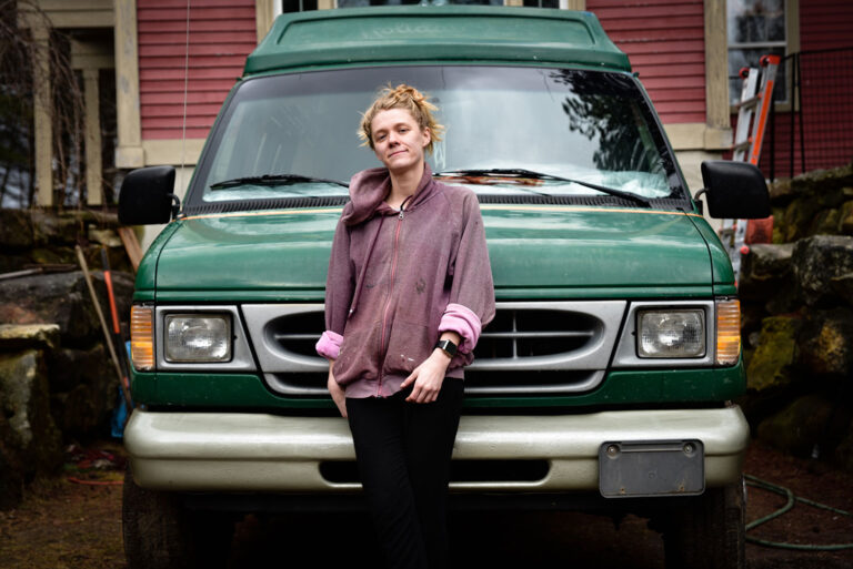 person standing in front of a green car