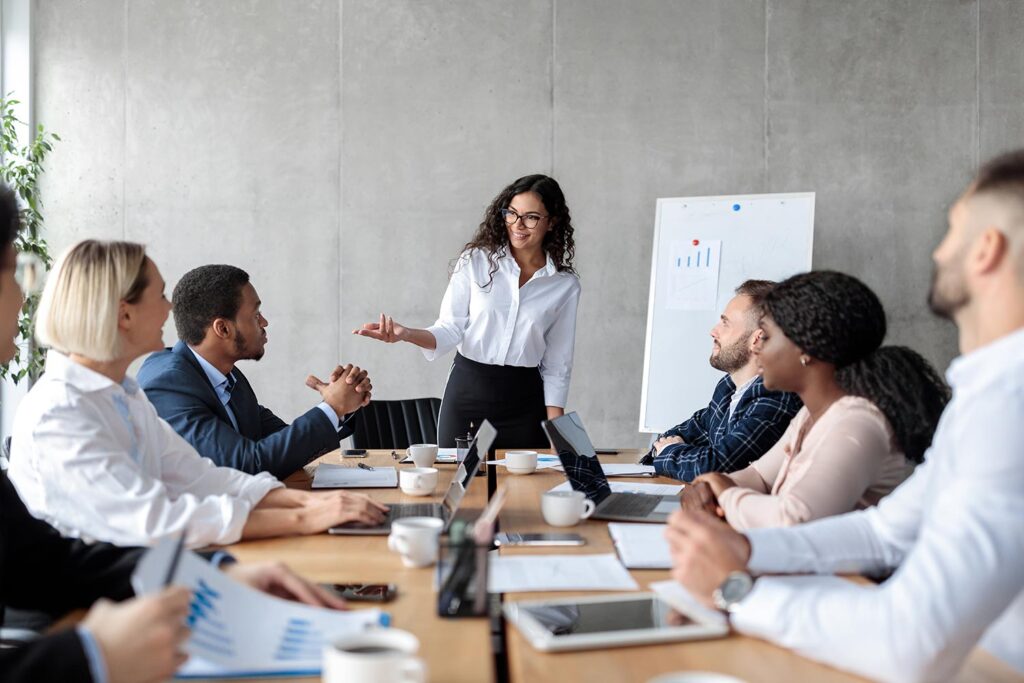 a group of business professionals talk around a meeting table