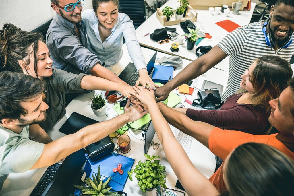 a group of people putting their hands in a pile