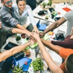 a group of people putting their hands in a pile