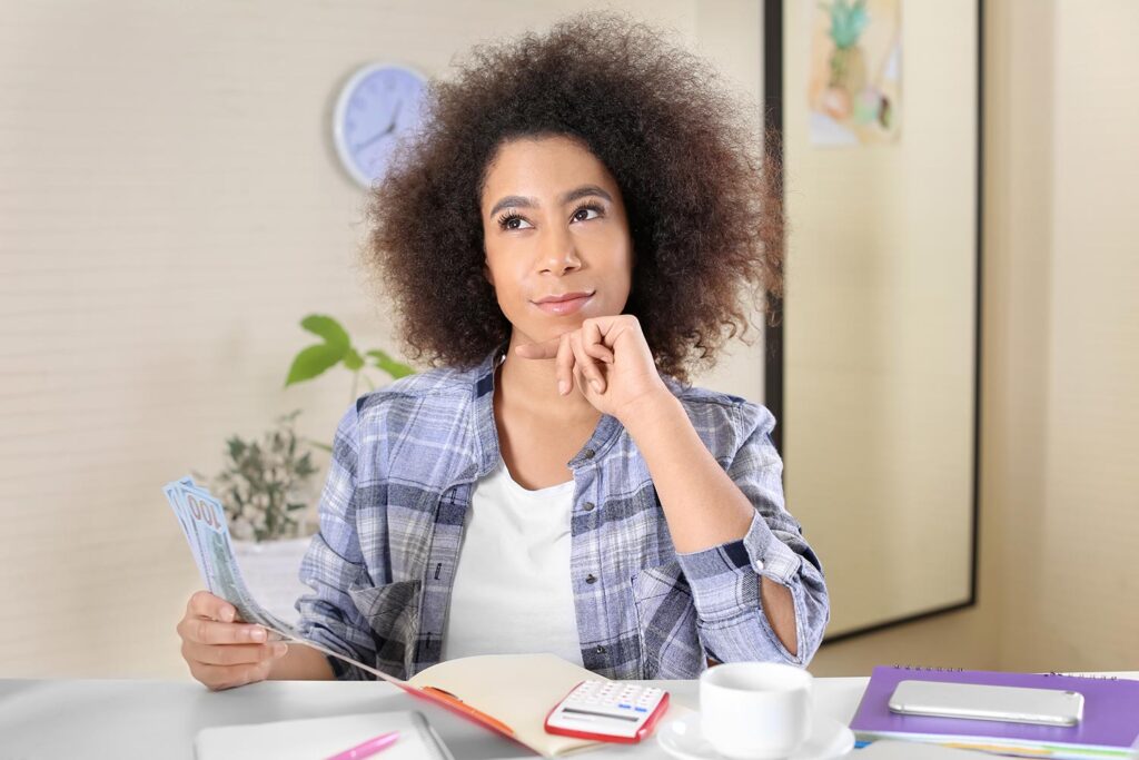 a woman holding money thinking to herself
