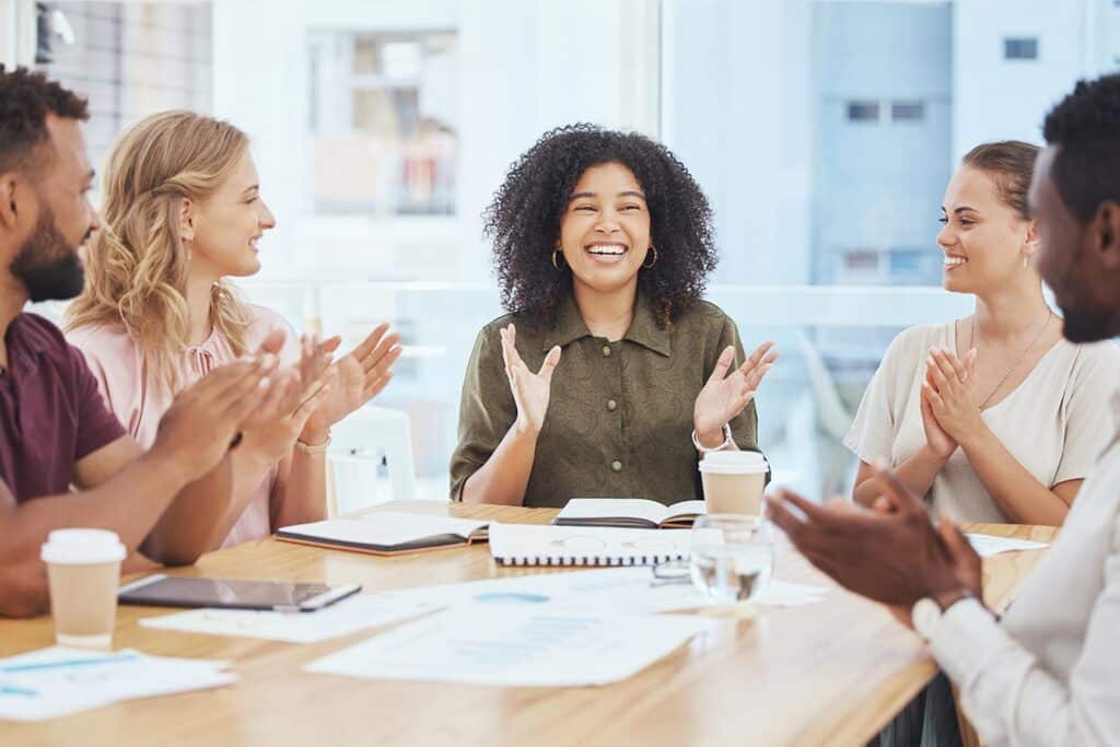 a groupof people at an office table clapping