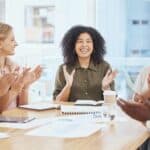a groupof people at an office table clapping