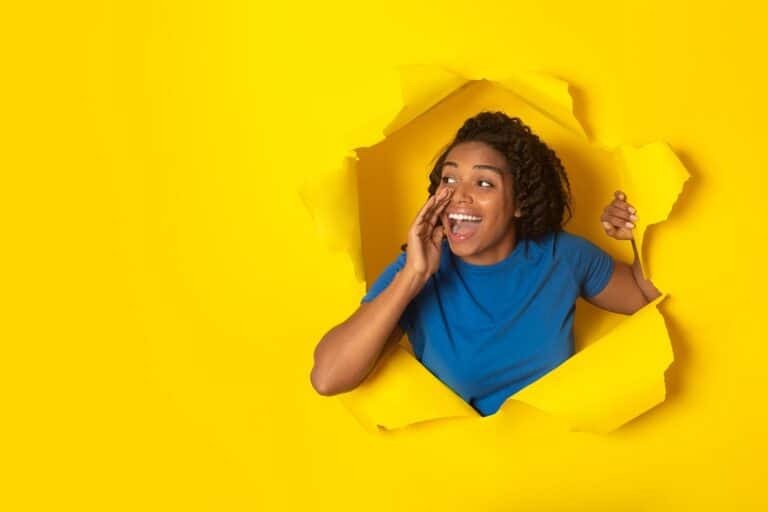 a person breaking through a paper background shouting