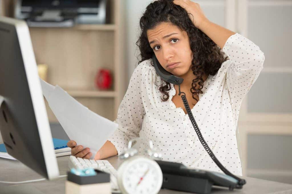 person on phone in an office looking stressed