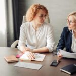 two women talking at a table