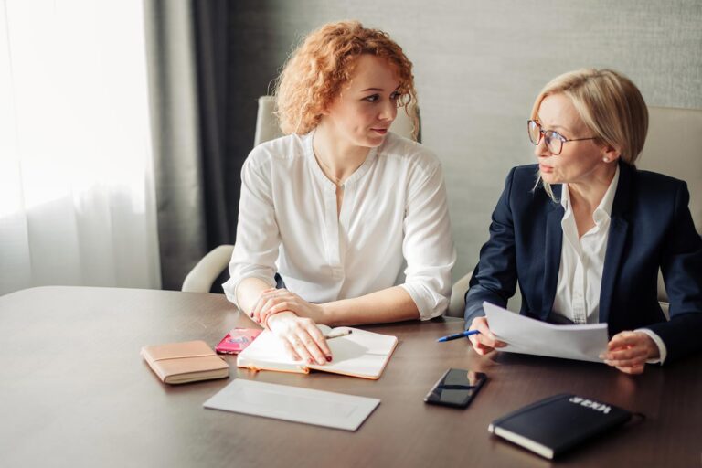 two women talking at a table